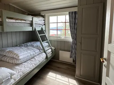 a bedroom with two bunk beds and a window at Kvetos fjellhytte in Beitostøl