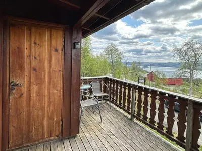 a wooden porch with a chair and a door at Kvetos fjellhytte in Beitostøl