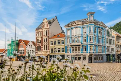 a group of buildings on a street with flowers at Dinbnb Apartments I Charming 3-Bedroom in the Heart of the City in Bergen