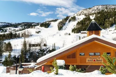 a ski lodge with a snow covered mountain in the background at Actif 106 - Hallingheim apartment ski inn/ski ut in Ål
