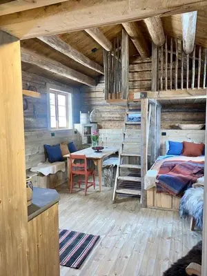 a bedroom with a bed and a table in a room at Sauefjøset - Idyllisk gardstun fra 1800-tallet in Skjåk