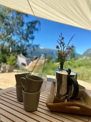 a table with cups and a tray with flowers on it at Sauefjøset - Idyllisk gardstun fra 1800-tallet in Skjåk