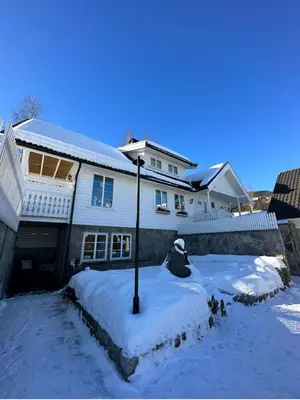a house with a light pole in the snow at Koselig leilighet i rolig boligfelt in Gol