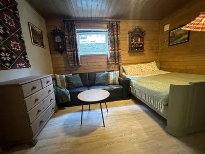 a bedroom with a bed and a couch and a table at Koselig leilighet i rolig boligfelt in Gol