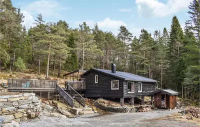 a log cabin in the woods with a stone wall at Stunning Home In Førde I Hordaland in Lier