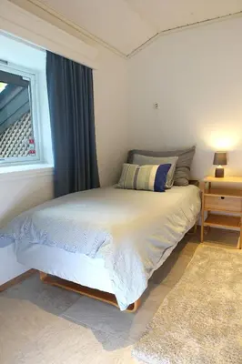 a bedroom with a large bed with a window at Villa Arboretet - Seaside villa with private pool & infrared sauna in the heart of Arboretet, Bergen in Bergen