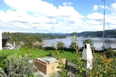 a view of a lake from a house at Villa Arboretet - Seaside villa with private pool & infrared sauna in the heart of Arboretet, Bergen in Bergen