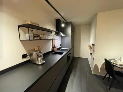 a kitchen with a counter and a table in a room at Studio Leilighet, nyoppusset in Langevåg