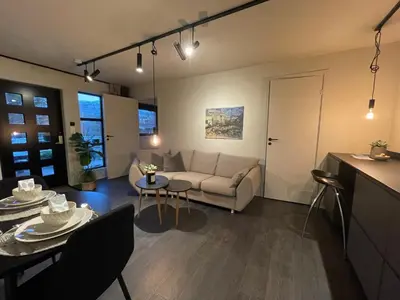a living room with a couch and a table at Studio Leilighet, nyoppusset in Langevåg