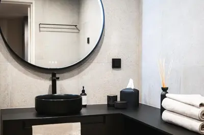 a bathroom with a black sink and a mirror at Studio Leilighet, nyoppusset in Langevåg