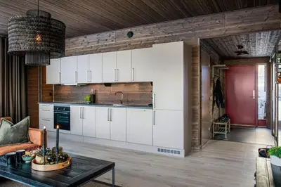 a kitchen with white cabinets and a table in a room at New ap The Nest in Hafjell ski in out and fast Wifi in Øyer