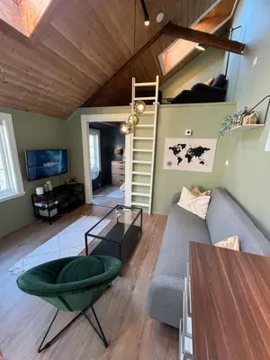 a living room with a couch and a stair case at Cozy backyard apartment in Trondheim
