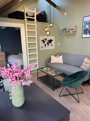 a living room with a couch and a loft bed at Cozy backyard apartment in Trondheim