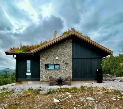 a small house with a roof on a hill at Brand new cabin on the sunny side of Gaustatoppen with a beautiful view in Tuddal