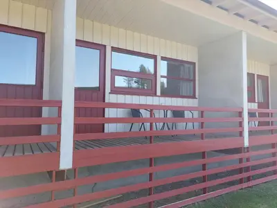 a front porch of a house with red railing at Øiseth Hotell AS in Rendalen