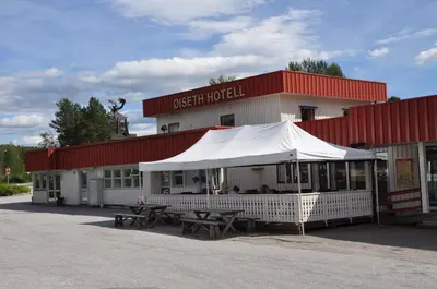 a restaurant with a white tent in front of a building at Øiseth Hotell AS in Rendalen