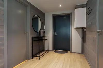 a hallway with a blue door and a mirror at Riddertunets glimt in Beitostøl