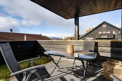 a patio with a table and chairs on a roof at Riddertunets glimt in Beitostøl