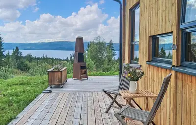 a wooden deck with two chairs and a stove at Awesome Home In Rauland With Sauna in Rauland