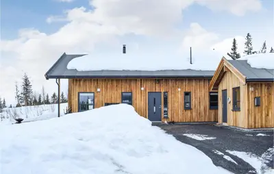 a wooden house with a pile of snow in front of it at Awesome Home In Rauland With Sauna in Rauland