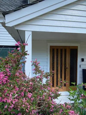 a front door of a house with pink flowers at Store Ringheim Apartment - Villa Hjadlane in Vossevangen