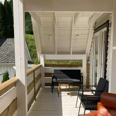a screened porch with a table and chairs on a house at Store Ringheim Apartment - Villa Hjadlane in Vossevangen