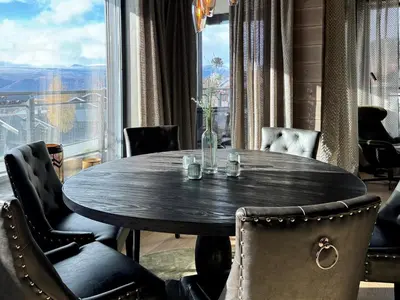a dining room table with chairs and a large window at Riddertunets harmoni in Beitostøl