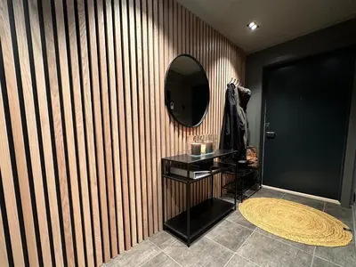 a bathroom with a mirror on a wooden wall at Riddertunets harmoni in Beitostøl