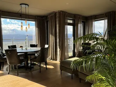 a dining room with a table and a large window at Riddertunets harmoni in Beitostøl