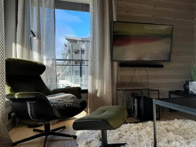 a living room with two chairs and a television at Riddertunets harmoni in Beitostøl
