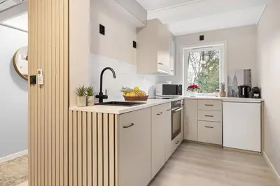 a kitchen with white cabinets and a sink at Apartments Bergen free parking in Bergen
