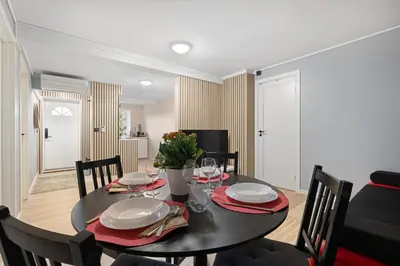 a dining room with a black table and chairs at Apartments Bergen free parking in Bergen
