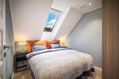 a bedroom with a large bed with a window at Meltzers Apartments in Bergen
