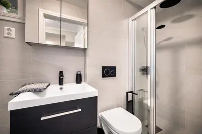 a bathroom with a sink and a toilet and a shower at Meltzers Apartments in Bergen