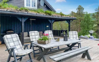 a patio with a wooden table and chairs on a deck at 3 Bedroom Gorgeous Home In Molde in Molde
