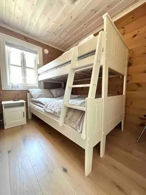a white bunk bed in a wooden room with a window at Lovise Mountain Apartment in Stranda