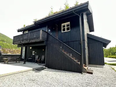 a black house with a balcony and a deck at Lovise Mountain Apartment in Stranda
