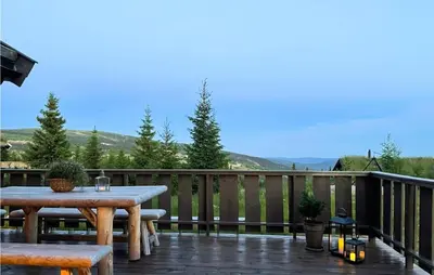a wooden deck with a table and benches on it at Amazing Home In Øyer With Sauna in Øyer