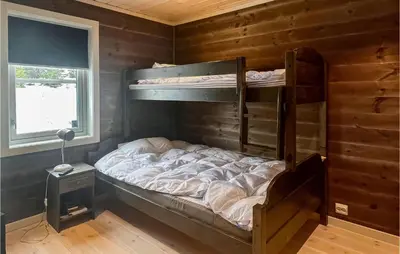 a bedroom with bunk beds in a wooden wall at Amazing Home In Øyer With Sauna in Øyer