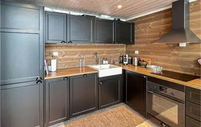 a kitchen with black cabinets and a sink at Amazing Home In Øyer With Sauna in Øyer