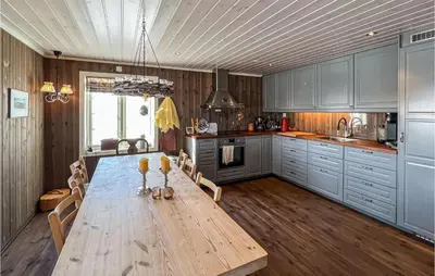 a kitchen with a wooden table with chairs and a tableasteryasteryasteryasteryastery at Amazing Home In Sjusjøen With Sauna in Sjusjøen