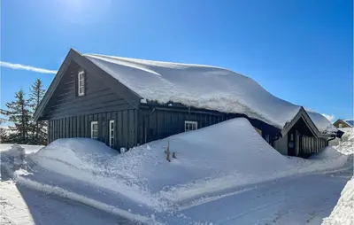 a barn covered in snow with a pile of snow at Amazing Home In Sjusjøen With Sauna in Sjusjøen