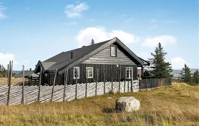a small wooden house on a hill with a fence at Amazing Home In Sjusjøen With Sauna in Sjusjøen