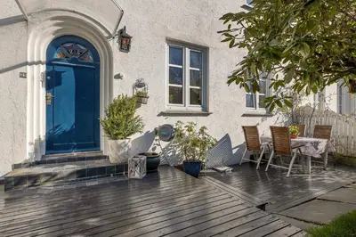a porch of a house with a table and chairs at Big central apartment w/ a view and parking in Bergen