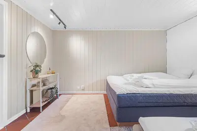 a bedroom with a bed and a mirror at Big central apartment w/ a view and parking in Bergen