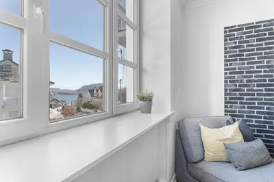 a living room with a window and a chair at Big central apartment w/ a view and parking in Bergen