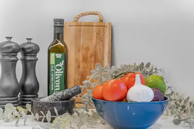 a bowl of vegetables sitting next to a bottle of wine at Big central apartment w/ a view and parking in Bergen