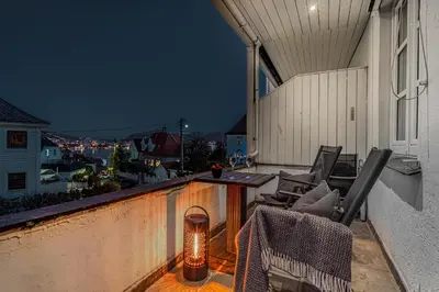 a balcony with chairs and a table and a light at Big central apartment w/ a view and parking in Bergen