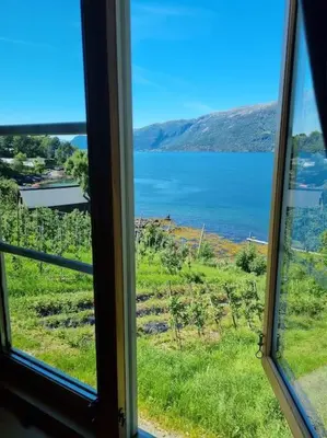 a window with a view of a body of water at Leilighet v Hardangerfjorden in Hesthamar