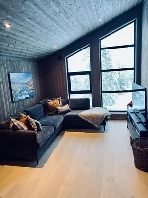 a living room with a couch and some windows at Norebu - Norefjell in Noresund